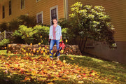 Photo of person using CRAFTSMAN cordless leaf blower SKU CMCBL700M1 in a yard with autumn leaves.