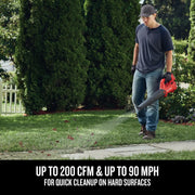 Photo of Craftsman CMCBL710M1 cordless leaf blower used to clear leaves from lawn near sidewalk, outdoor setting.