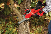 Photo of Craftsman CMCCSL621D1 cordless chainsaw cutting a tree branch outdoors, operator wearing gloves.