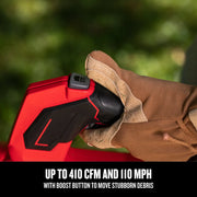 Closeup of Craftsman leaf blower handle with boost button, SKU CMCK497P1, glove pressing control outdoors.
