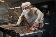 Person using CRAFTSMAN CMCM300B cordless metal cutting saw, generating sparks while cutting steel in workshop.
