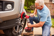 Photo of Craftsman CMCPS520D1 cordless power scrubber cleaning a truck tire with a red brush attachment.