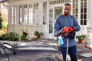 Photo of person using Craftsman CMCPW350D1 cordless power cleaner spraying water on a car, outdoor setting.