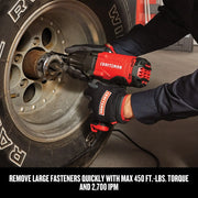 Photo of Craftsman CMEF901 impact wrench used on a vehicle wheel, red and black tool held by gloved hands.