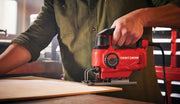 Photo of Craftsman jigsaw CMES610 cutting wood, red and black design, used by person in workshop.
