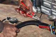 Photo of CRAFTSMAN diagonal cutting pliers CMHT82508 with red handles cutting a zip tie on a wire bundle.