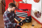 Photo of a person wearing Craftsman gloves working at a bench with a Craftsman red toolbox, SKU CMST98245RB.