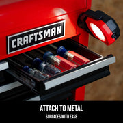 Photo of Craftsman CMST98254 red magnetic work light attached to metal tool chest near open drawer with screwdrivers.