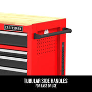 Close-up of a red Craftsman tool chest with a wooden top, showing a black tubular side handle and a built-in power strip on the side. Text at the bottom reads: 'Tubular side handles for ease of use.'