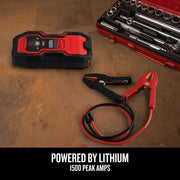 Photo of Craftsman CMXCESM264 portable jump starter with cables, next to a red tool kit on a workbench.