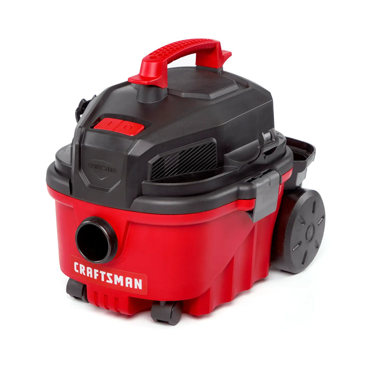 A portable red and black wet/dry vacuum cleaner with a handle on top, large wheels, and the brand name 'CRAFTSMAN' visible on the front.