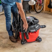 Photo of a Craftsman wet/dry vacuum, SKU CMXEVBE17606, with red canister, black attachments, shown in a garage setting.