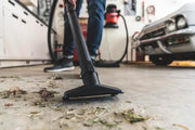 Photo of a Craftsman wet/dry vacuum CMXEVBE17925 cleaning debris from a garage floor, close-up angle.