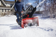 Photo of Craftsman CMXGBAM1054546 snow blower clearing snow in a residential driveway.
