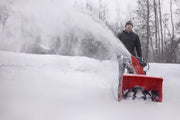 Photo of a red CRAFTSMAN snow blower, SKU CMXGBAM213102, in use clearing snow outdoors.