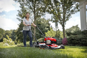 Photo of Craftsman CMXGMAM2703840 red walk-behind lawn mower in use outdoors on green grass.