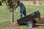 Photo of a Craftsman dump cart SKU CMXGZBF7124355 being used to unload mulch around a tree in a yard.