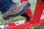 Photo of Craftsman CMXGZBF7124355 red metal yard tool with foot pressing black pedal outdoors.