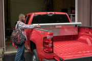 Photo of Craftsman truck toolbox CMXTBAK1050901 installed on red pickup truck in a workshop setting.