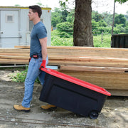 Person pulling Craftsman rolling storage bin with red lid, SKU CMXXPBP50GTW, black body, outdoor side view.