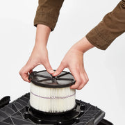 Photo of hands installing Craftsman vacuum filter CMXZVBE38741 onto a black base, close-up, white background.