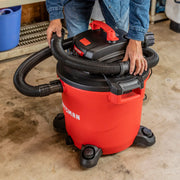 Photo of Craftsman wet/dry vacuum, SKU CMXZVBE38749, red and black, with hose attachment, in a garage setting.