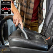 CRAFTSMAN CMXZVBE38755 auto vacuum hose cleaning black car seat, close-up view, crumbs visible.