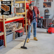 Photo of person using Craftsman wet/dry vacuum CMXZVBE38803 to clean wood debris on workshop floor.