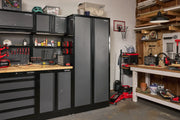 A well-organized garage workshop featuring CRAFTSMAN gray and black storage cabinets, tool drawers, and a workbench. Various